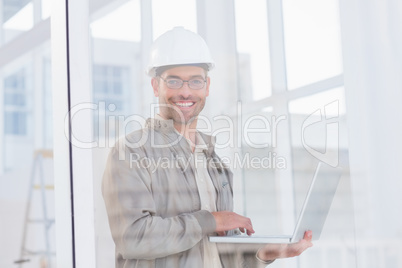 Smiling male architect using laptop in office