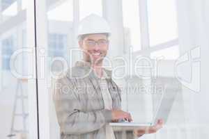 Smiling male architect using laptop in office