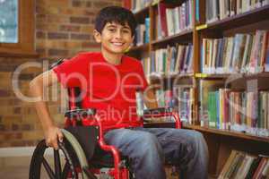 Portrait of boy sitting in wheelchair at library