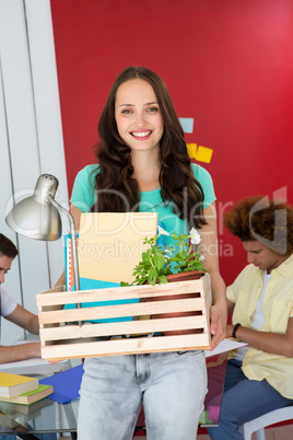 Casual businesswoman carrying her belongings in box