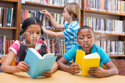 Cute pupils reading in library