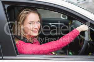 Young woman driving and smiling