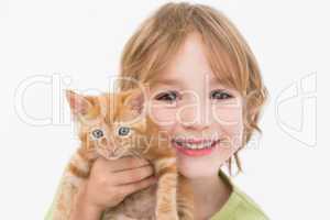 Close-up portrait of cute boy holding kitten