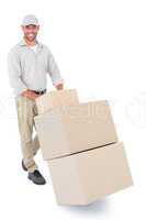 Happy delivery man pushing trolley of boxes