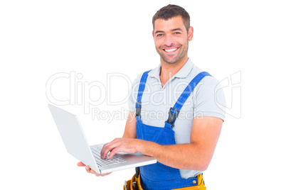Portrait of smiling handyman using laptop