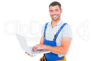 Portrait of smiling handyman using laptop