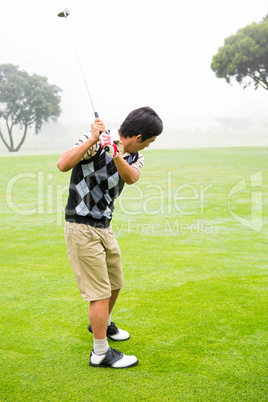 Golfer teeing off