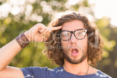 Handsome hipster looking surprised in park