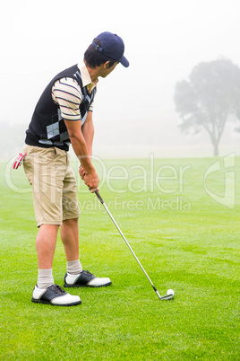 Concentrate golfer lining up his shot