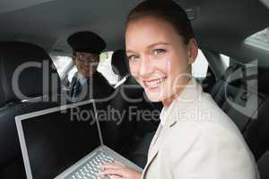 Businesswoman being chauffeured while working
