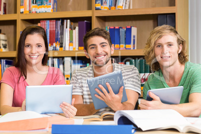 College students using digital tablets in library