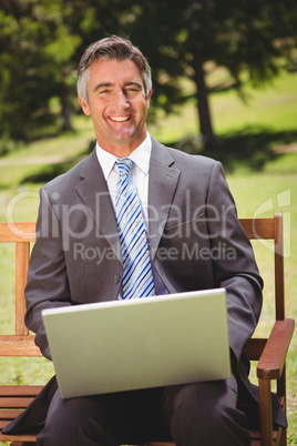 Businessman using laptop in the park Businessman using laptop in the park