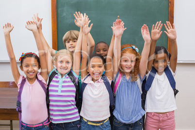 Cute pupils smiling at camera in classroom