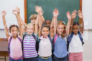 Cute pupils smiling at camera in classroom