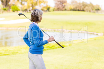 Female golfer standing holding her club
