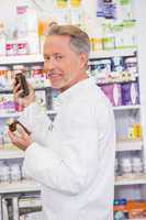 Senior pharmacist taking jar from shelf