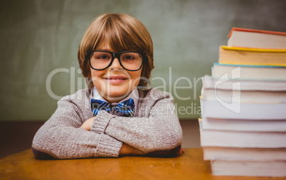 Boy with stack of books in classroom