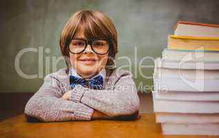 Boy with stack of books in classroom