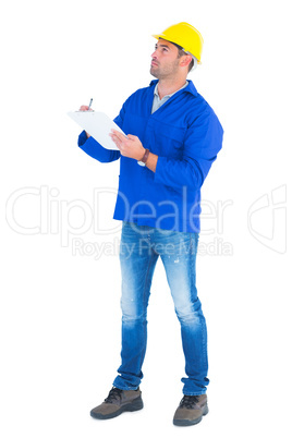 Manual worker looking up while writing on clipboard