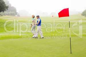 Golfing couple walking on the putting green