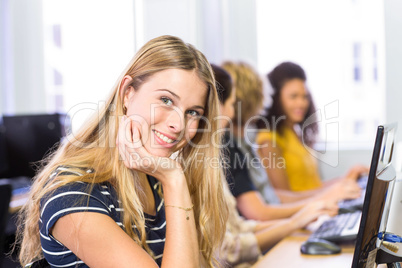 Student smiling at camera in computer class