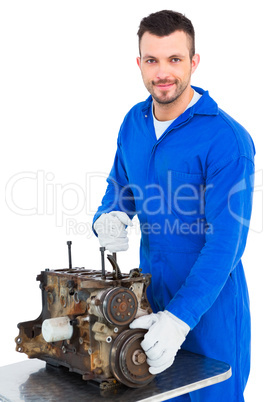 Smiling male mechanic repairing car engine