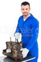 Smiling male mechanic repairing car engine