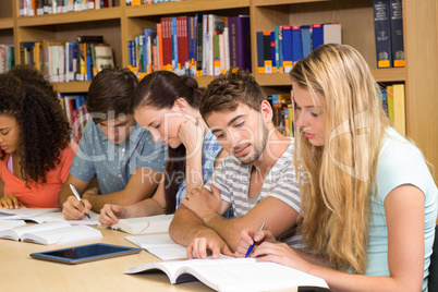 College students doing homework in library