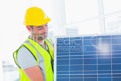Handyman carrying solar panel at office