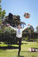 Businessman throwing briefcase and newspaper