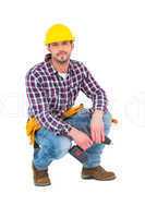 Crouching handyman holding power drill