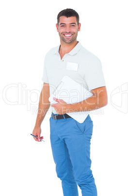 Smiling male handyman with clipboard and pen on white background