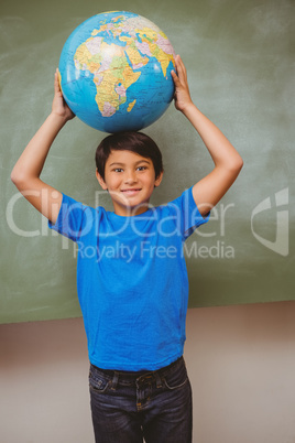 Little boy holding globe over head