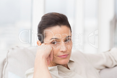 Thoughtful woman sitting on sofa