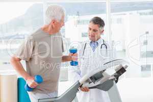 Senior man on treadmill with therapist