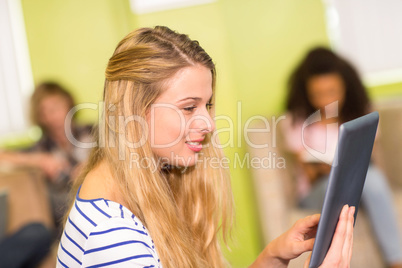 Casual young woman using digital tablet in office