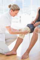 Doctor examining her patient knee