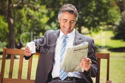 Businessman reading newspaper in the park