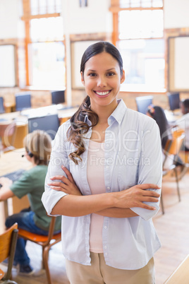 Pretty teacher smiling at camera at back of classroom