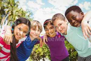 Happy children forming huddle at park