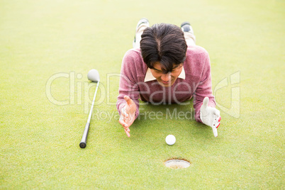Golfer lying near golf ball