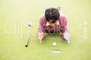 Golfer lying near golf ball