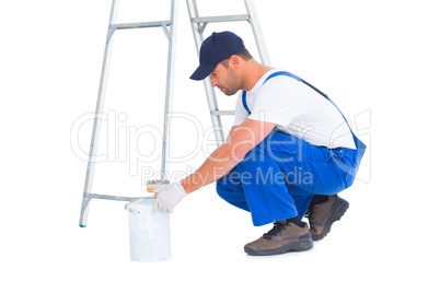 Side view of handyman with paint can on white background