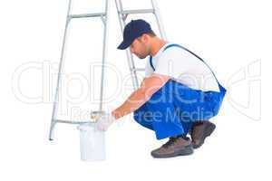 Side view of handyman with paint can on white background