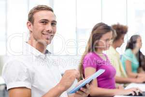Male student using digital tablet in computer class