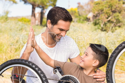 Father and son repairing bike together