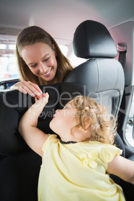 Mother checking her baby in the car seat