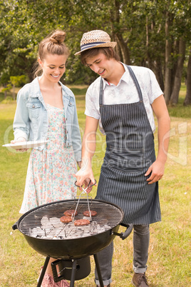 Happy friends in the park having barbecue