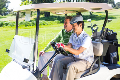 Golfing friends laughing together in their golf buggy