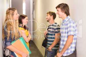 Students with files standing at college corridor